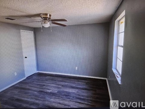A room with a ceiling fan and a window.
