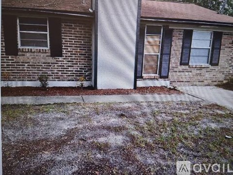 A house with a brown brick exterior and a white garage door.