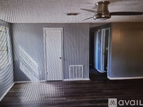A room with a ceiling fan and a door.