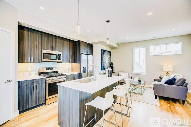 A modern kitchen with a breakfast bar and a living room area.