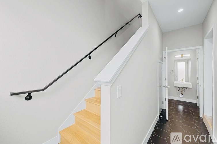 A staircase with a black handrail and wooden steps.