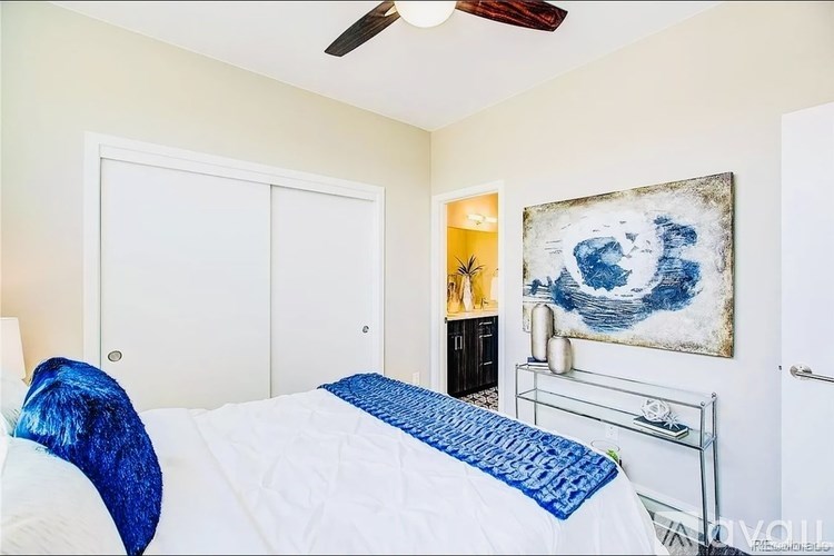 A bedroom with a bed, a dresser, and a painting on the wall.