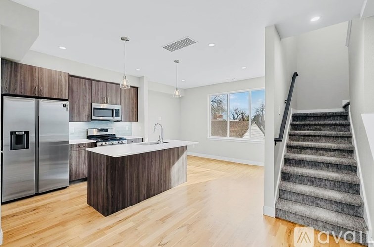 A modern kitchen with a refrigerator, sink, and stove.