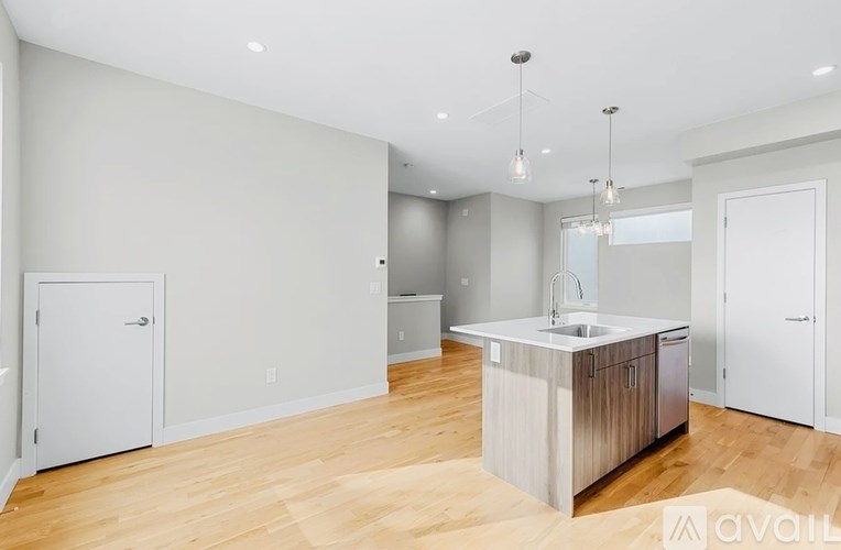 A modern kitchen with a wooden floor and white walls.