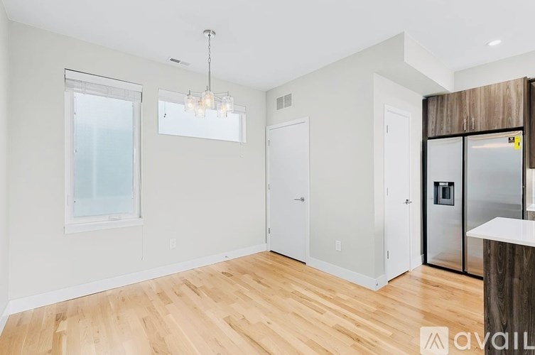 A room with wooden floors and a white wall with a window.