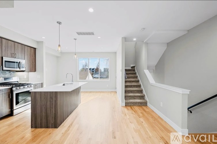 A modern kitchen with wooden cabinets and a stainless steel oven.