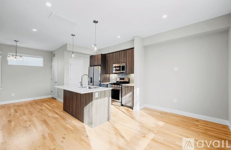 A modern kitchen with wooden floors and a center island.