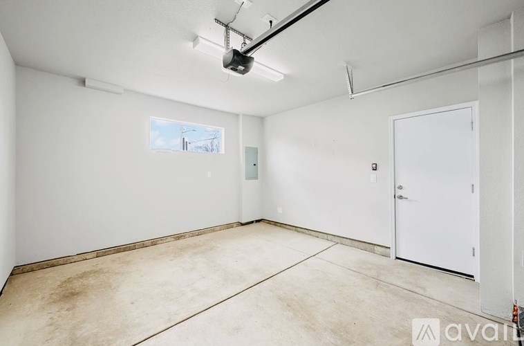 A large empty room with a window and a door.