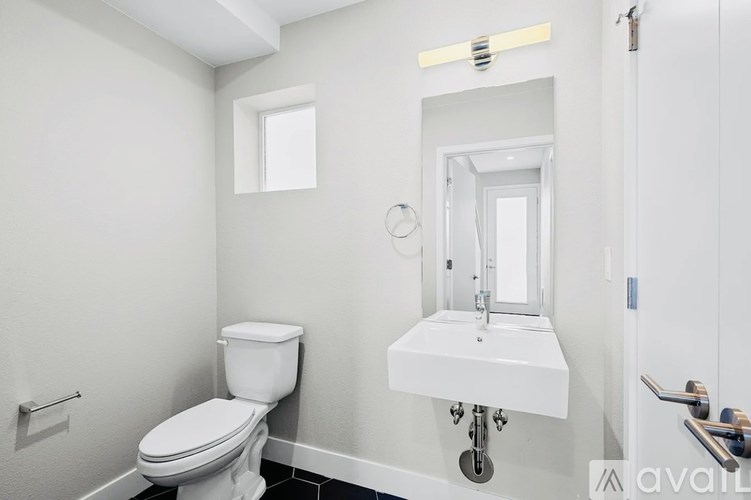 A white toilet and sink in a small bathroom.