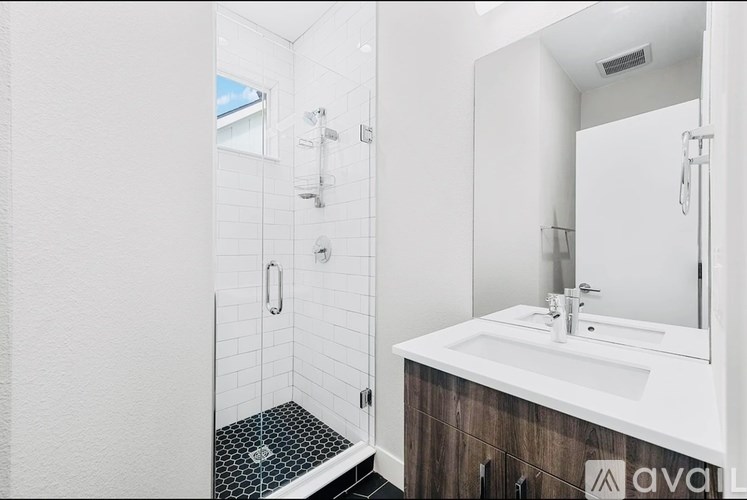 A white bathroom with a walk in shower and a sink.