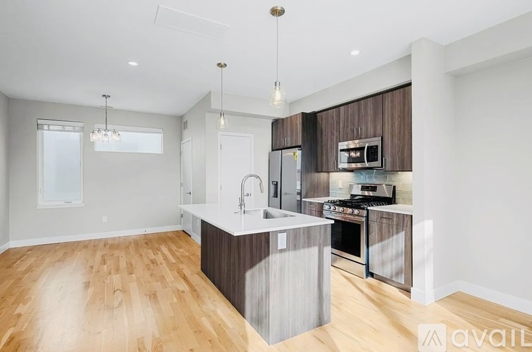 A modern kitchen with wooden floors and a central island.