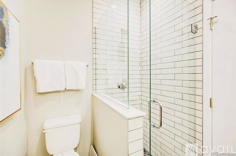 A white toilet sits next to a glass shower door in a bathroom.