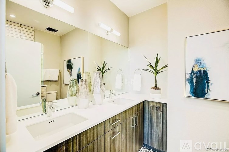 A bathroom with a white sink and a large mirror.