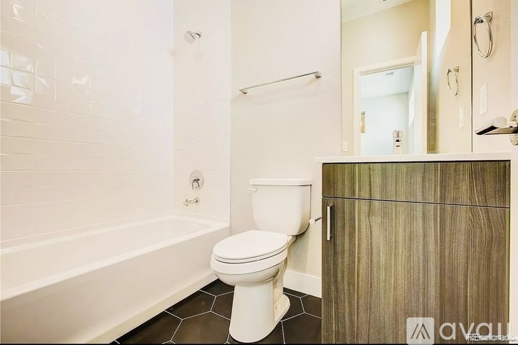 A white toilet in a bathroom with a wooden cabinet.