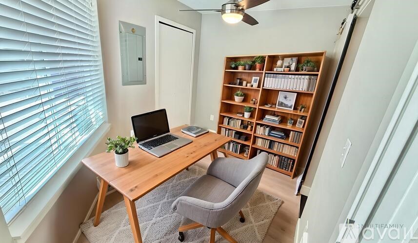A room with a desk, chair, and a bookshelf.