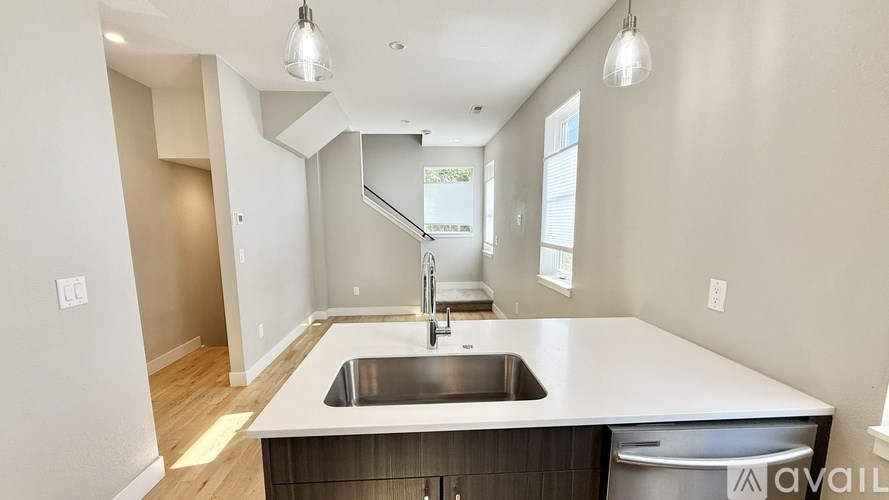 A modern kitchen with a stainless steel sink and dishwasher.