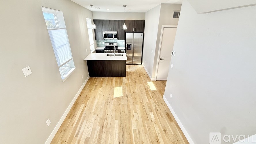 A kitchen with wooden floors and white walls.