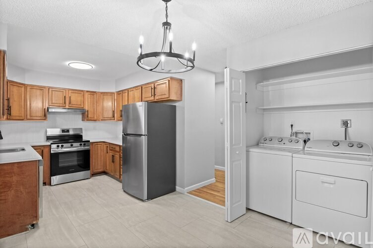 A kitchen with wooden cabinets and a stainless steel refrigerator.