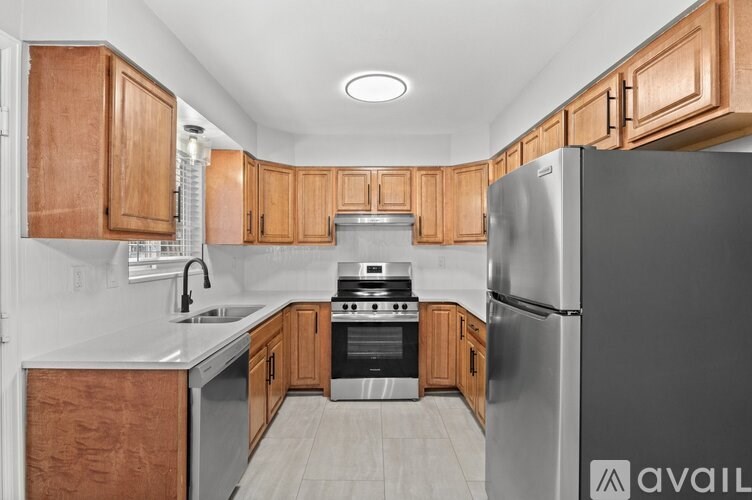 A kitchen with wooden cabinets and a refrigerator.