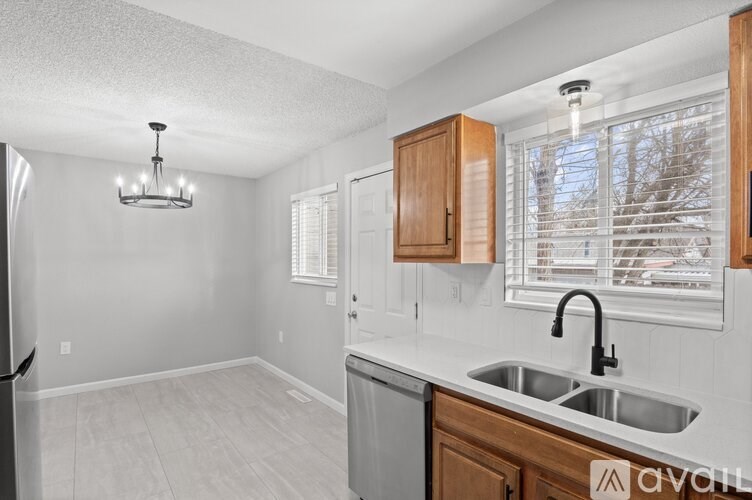A kitchen with a white sink and wooden cabinets.