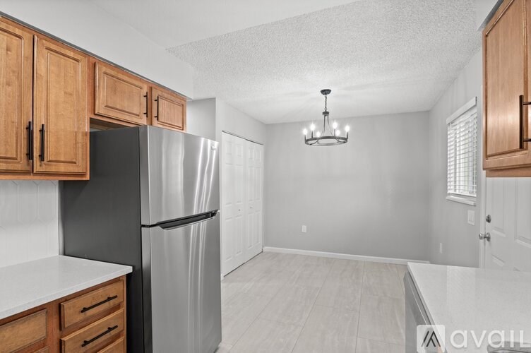 A kitchen with wooden cabinets and a black refrigerator.