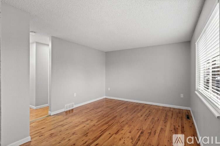 A room with wooden flooring and white walls.