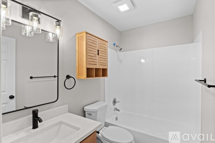 A bathroom with a white tub, sink, and toilet.