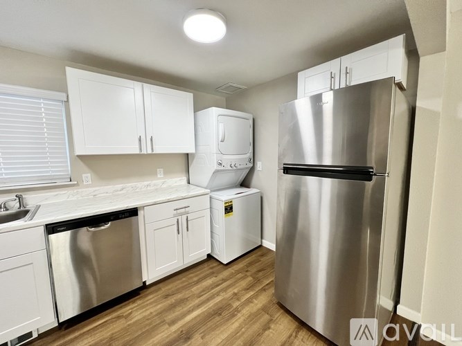 A kitchen with white cabinets and a stainless steel refrigerator.