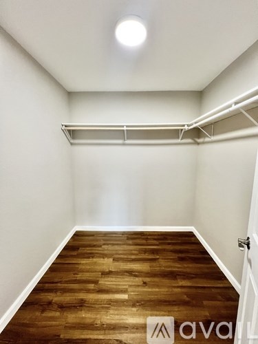 A room with wooden flooring and white walls.