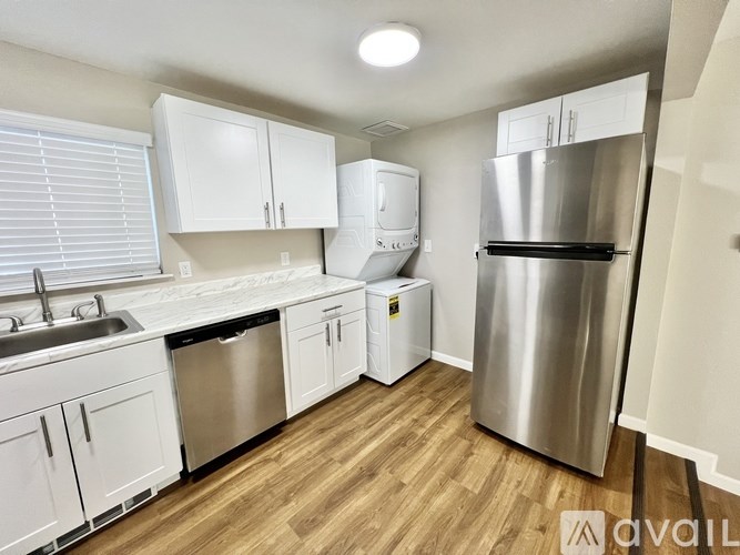 A kitchen with white cabinets and a stainless steel refrigerator.
