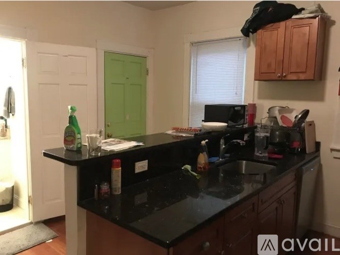 A kitchen with black countertops and wooden cabinets.