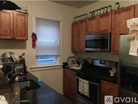 A kitchen with wooden cabinets and black appliances.