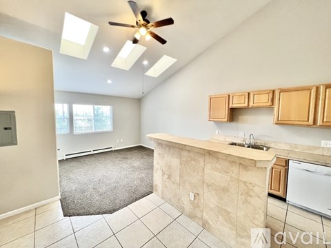 A kitchen with a white ceiling fan and wooden cabinets.