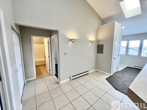 A spacious room with a skylight and a radiator on the wall.