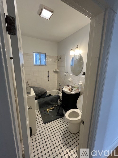 A bathroom with a toilet, sink, and mirror.