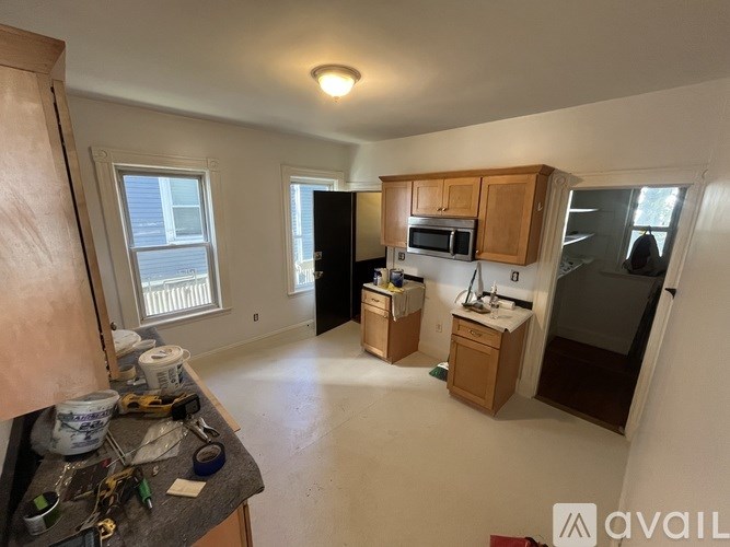 A kitchen with wooden cabinets and a microwave.
