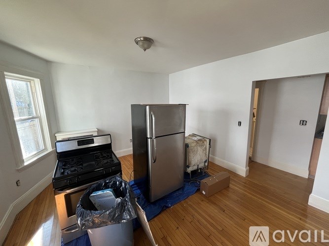 A kitchen with a stove, refrigerator, and a blue mat on the floor.