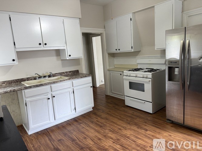 A kitchen with white cabinets and a granite countertop.