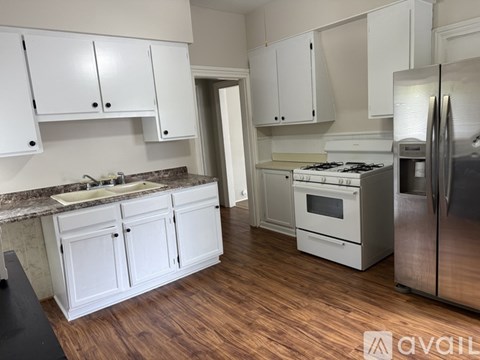 A kitchen with white cabinets and a granite countertop.
