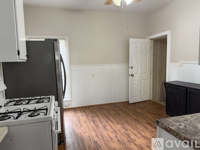 A kitchen with a black fridge and a white door.