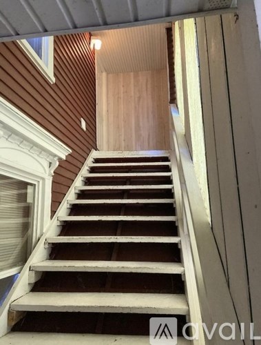 A wooden staircase with a white railing.