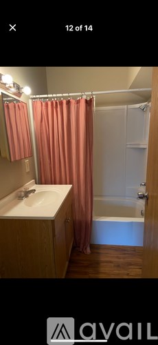 A bathroom with a sink, mirror, and shower.