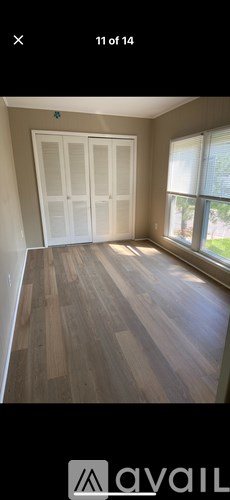 A room with wooden flooring and a white door.