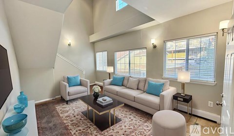A living room with a white couch, a coffee table, and a rug.
