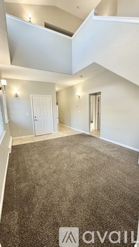 A carpeted room with a skylight and two doors.