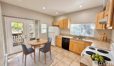 A kitchen with a table and chairs in front of a window.