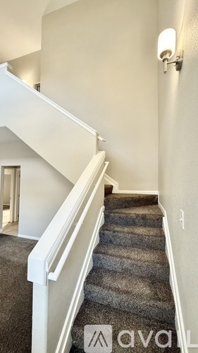 A staircase with a carpeted runner and white balusters.