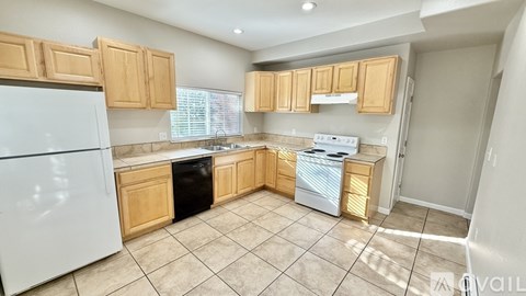 A kitchen with white appliances and wooden cabinets.