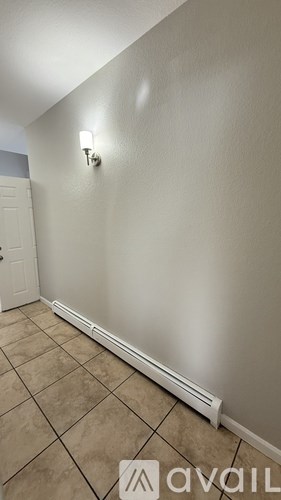A wall with a light switch and a white baseboard heater.