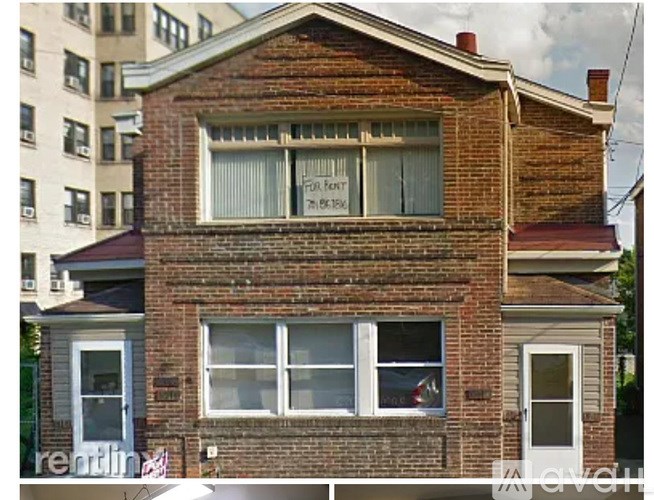 A brick house with a sign that says "For Rent".